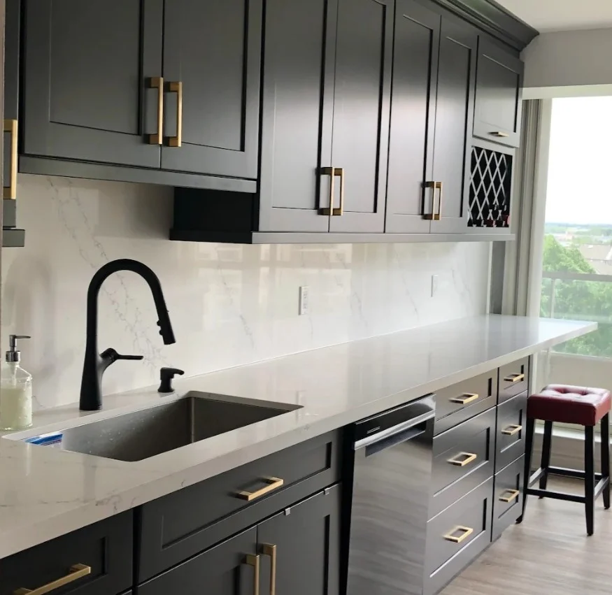 Dark charcoal grey shaker condo kitchen with gold brass hardware white quartz countertops black matte faucet and wine rack